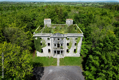 A big ruin house covered ivy and surrounded by a forest , Moore Hall is located in county Mayo Ireland and is now a public area