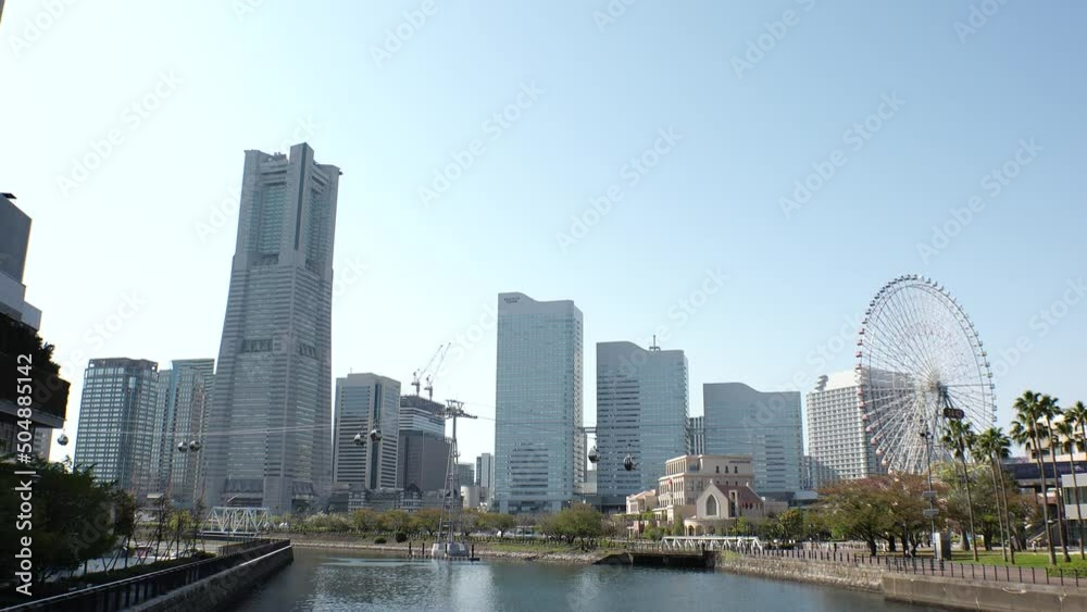SAKURAGICHO, YOKOHAMA, JAPAN : Cityscape of Yokohama “Minatomirai” area. View of tall buildings at downtown area, near the harbor. Time lapse shot in sunny daytime. SAKURAGICHO, YOKOHAMA, JAPAN : Cityscape of Yokohama “Minatomirai” area. View of tall buildings at downtown area, near the harbor. Time lapse shot in sunny daytime.