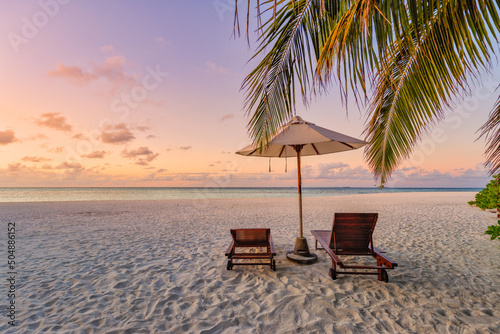 Couple travel background  luxury resort beach with chairs and umbrella. Sunset landscape  coast sea bay. Tranquil paradise island  colorful sunset. Sea sand sky  beautiful summer beach  love romance