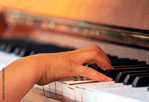 fingers the right hand of a young pianist plays exercises on the white keys of the piano, music education