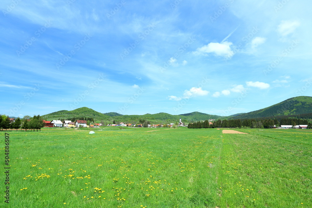 Green meadow and panoramic view on village Mrkopalj in Gorski kotar area, Croatia