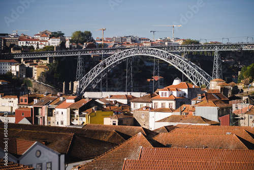 View of rooftops of port wine cellars in Vila Nova de Gaia and the Dom Luis I Bridge, Porto, Portugal.