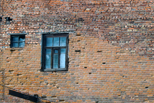 An abandoned old window in a dirty red brick wall