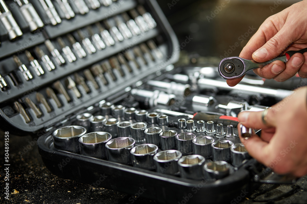 Man hand open set box with working tools different types of metal steel heads and bits at the workshop, Interchangeable screwdriver set. Man hand open set box with working tools different types of metal steel heads and bits at the workshop, Interchangeable screwdriver set.