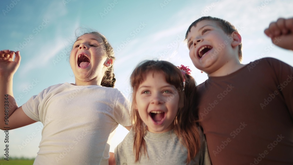 group of kids team hugging a jumping and rejoicing outdoors. happy family teamwork kid dream concept. family children sisters brothers have fun sun hugging in the park in nature group of kids team hugging a jumping and rejoicing outdoors. happy family teamwork kid dream concept. family children sisters brothers have fun sun hugging in the park in nature