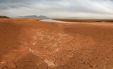 The shore of the Krasnoyarsk reservoir without water, sandy ripples, clay and hills, rainy sky over Mount Tepsey Tepsei