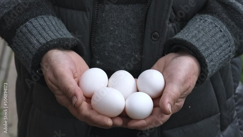 Farmer hands holding organic eggs on a farm