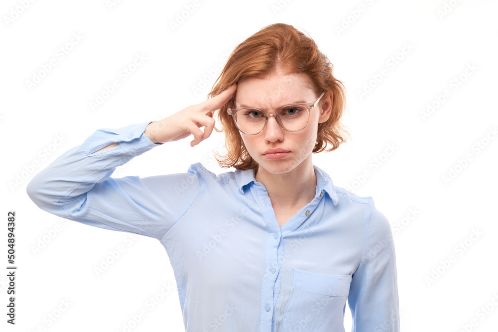 Smart redhead girl in business shirt and glasses touches head thinks doubts, makes decision isolated on white studio background Smart redhead girl in business shirt and glasses touches head thinks doubts, makes decision isolated on white studio background