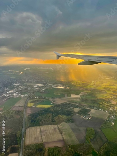 Landendes Flugzeug mit Abendhimmel und Sonnenstrahlen über Niedersachsen / Bremen
