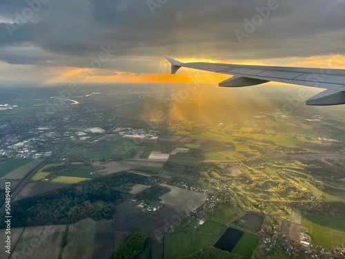 Landendes Flugzeug mit Abendhimmel und Sonnenstrahlen über Niedersachsen / Bremen