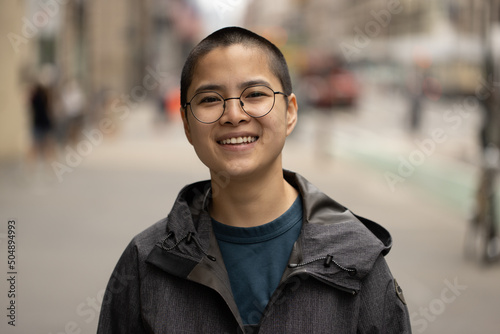 Asian non-binary person on a city street portrait smiling happy photo