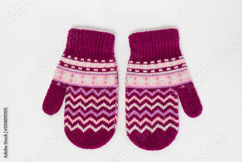 A pair of pink knitted mittens isolated on a white background.