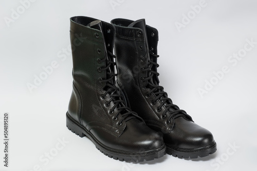 A pair of black leather military boots isolated on a white background.