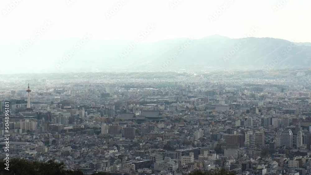 KYOTO, JAPAN - DECEMBER 2021 : Aerial high angle view of Kyoto city. Scenery of mountain, streets and buildings around downtown central area. Long time lapse shot in daytime. KYOTO, JAPAN - DECEMBER 2021 : Aerial high angle view of Kyoto city. Scenery of mountain, streets and buildings around downtown central area. Long time lapse shot in daytime.