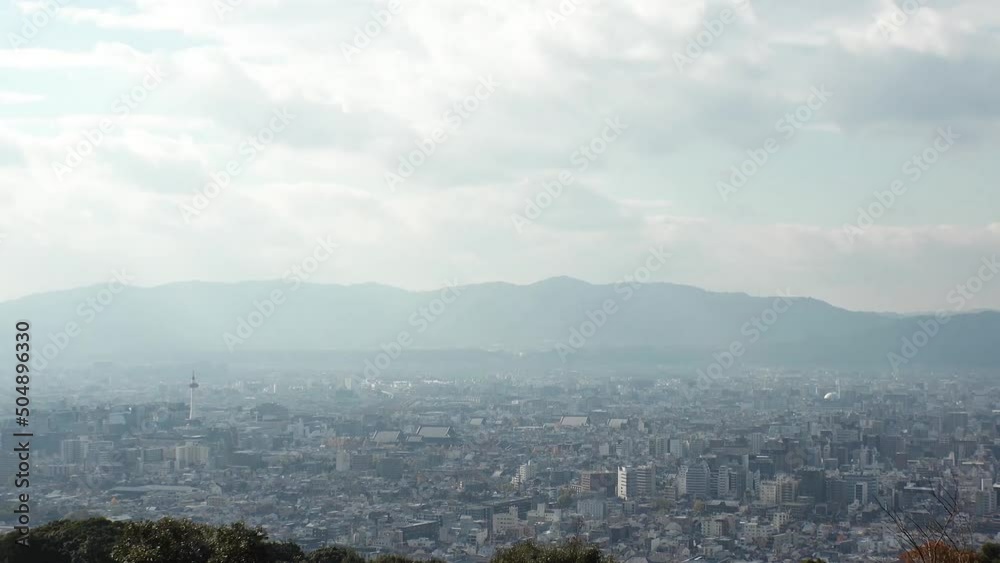 KYOTO, JAPAN - DECEMBER 2021 : Aerial high angle view of Kyoto city. Scenery of mountain, streets and buildings around downtown central area. Long time lapse shot in daytime. KYOTO, JAPAN - DECEMBER 2021 : Aerial high angle view of Kyoto city. Scenery of mountain, streets and buildings around downtown central area. Long time lapse shot in daytime.