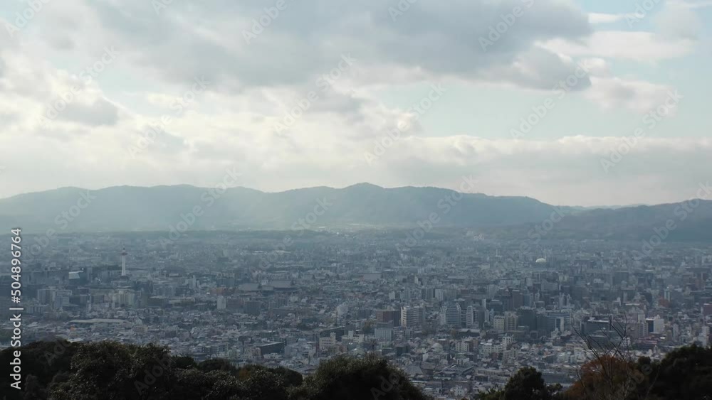 KYOTO, JAPAN - DECEMBER 2021 : Aerial high angle view of Kyoto city. Scenery of mountain, streets and buildings around downtown central area. Long time lapse shot in daytime. KYOTO, JAPAN - DECEMBER 2021 : Aerial high angle view of Kyoto city. Scenery of mountain, streets and buildings around downtown central area. Long time lapse shot in daytime.