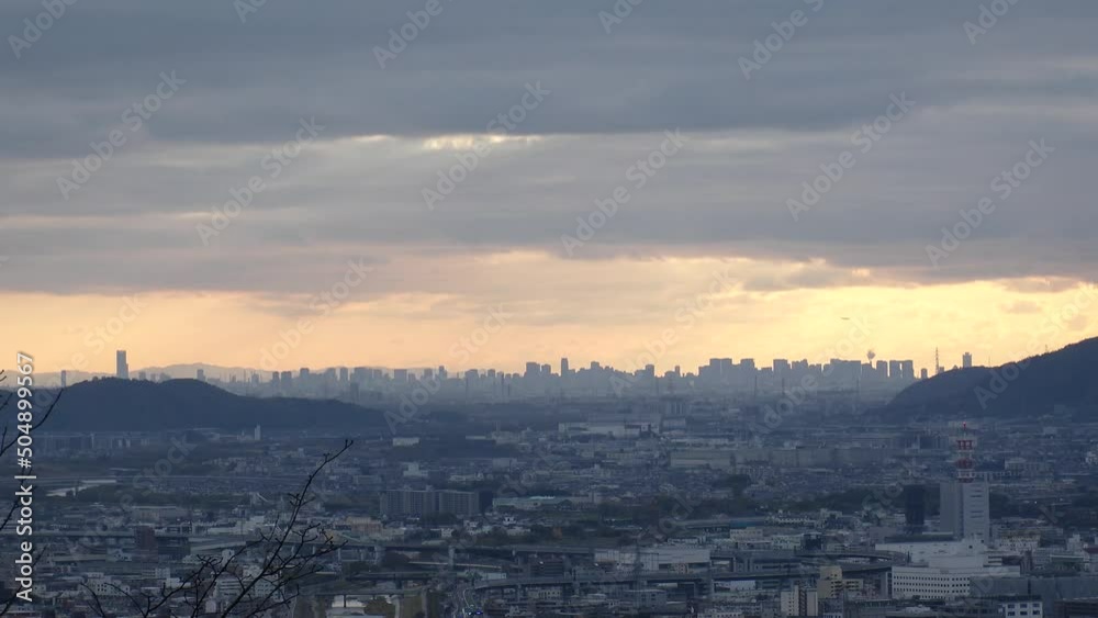 OSAKA, JAPAN - DECEMBER 2021 : Aerial panoramic view of downtown buildings at Osaka city in sunset time. View from Kyoto city. Time lapse shot in dusk. Japanese urban city concept video. OSAKA, JAPAN - DECEMBER 2021 : Aerial panoramic view of downtown buildings at Osaka city in sunset time. View from Kyoto city. Time lapse shot in dusk. Japanese urban city concept video.