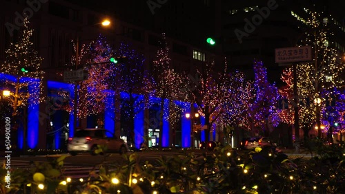 OSAKA, JAPAN - DECEMBER 2021 : View of Christmas illumination led light up at Midosuji street. Scenery of downtown city and street at night. Japanese winter and Christmas season concept. photo