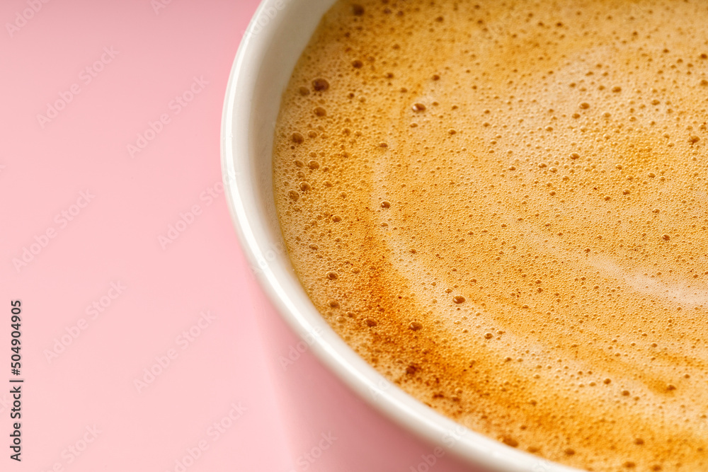 Coffee milk foam in cup. Background texture of cappuccino, closeup. Macro. Pink background