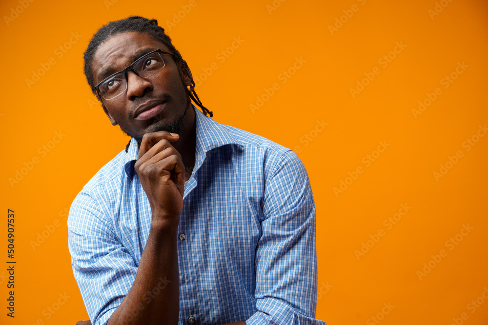 Pensive afro man portrait on orange background Pensive afro man portrait on orange background