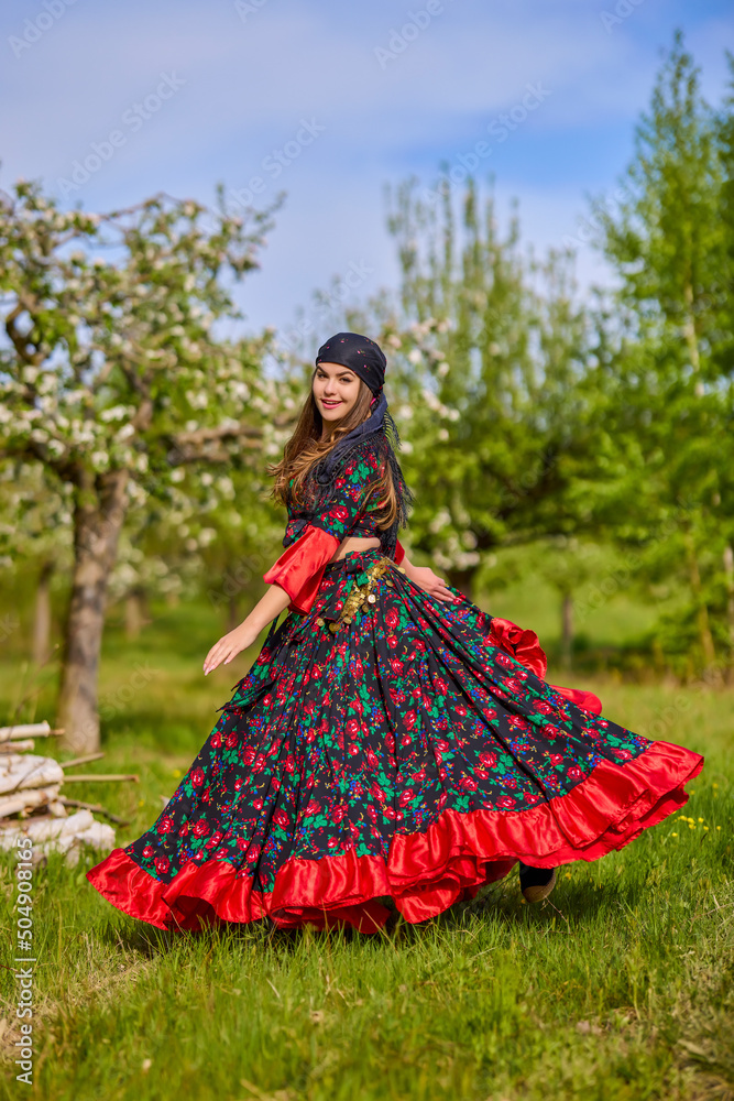 Fototapeta premium beautiful woman in traditional gypsy dress posing in nature in spring