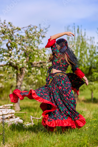 beautiful woman in traditional gypsy dress posing in nature in spring