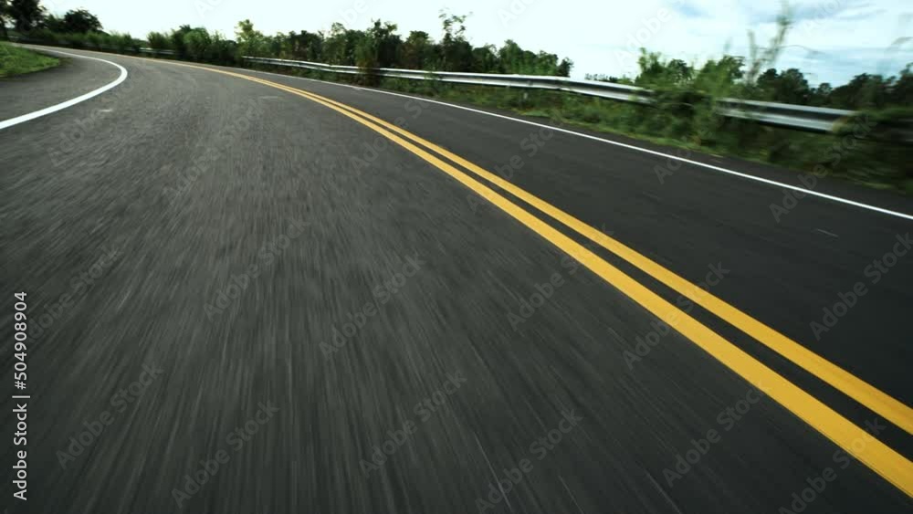 Front pov view of fast car driving on asphalt road with double yellow lines converge
