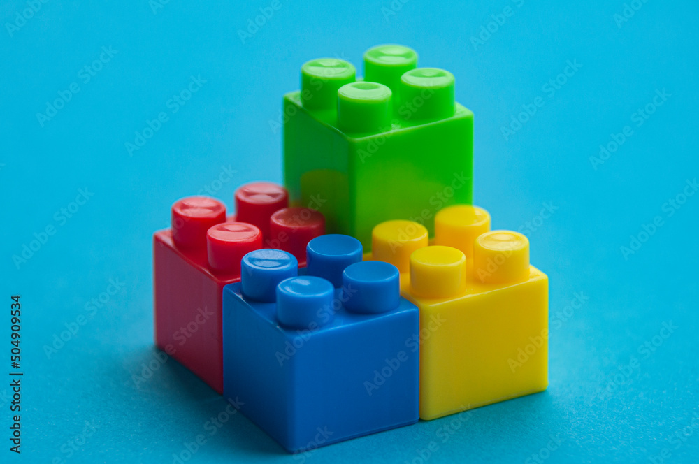 Plastic building blocks on blue background. Educational concept Plastic building blocks on blue background. Educational concept