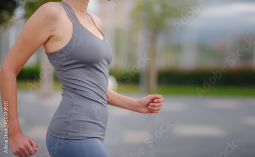 outdoor sports, workout and wellness concept. Closeup shot of a fitness woman running outdoors, depersonalized photograph, close-up view of the body