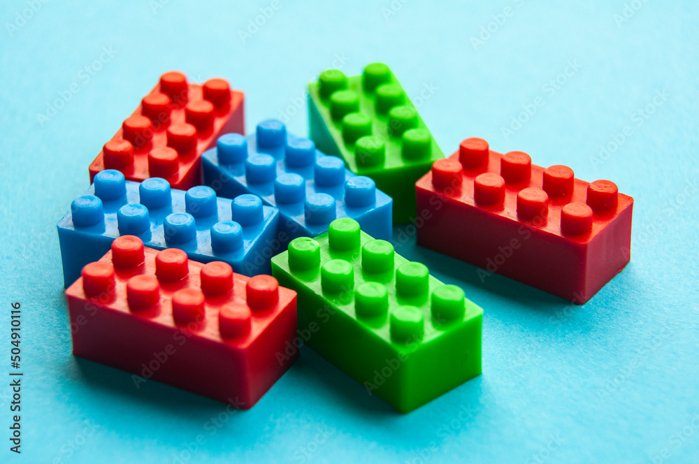 Fototapeta premium Plastic building blocks on blue background. Educational concept