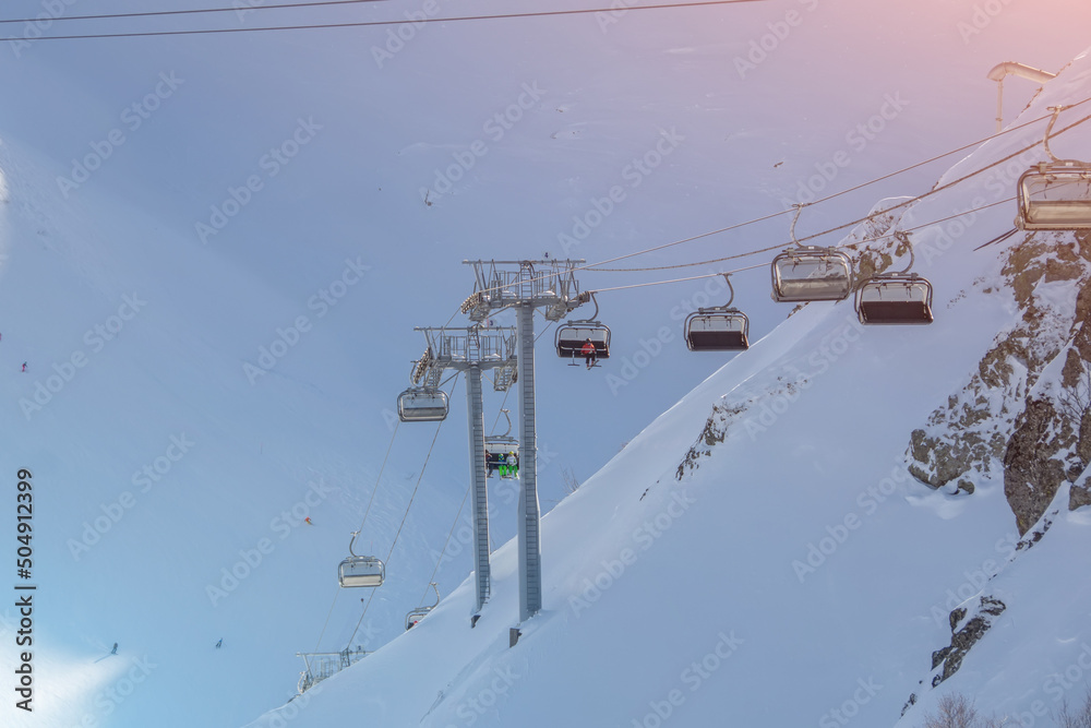 Lifts with open cabins seats in the snowy mountains.