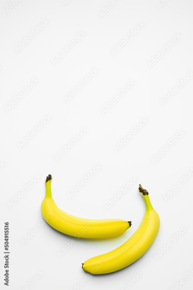 Top view of yellow bananas on white background with copy space. Top view of yellow bananas on white background with copy space.