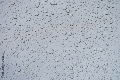Closeup of raindrops on gray window glass texture background