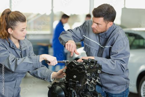 Obraz na plátne mechanic guiding apprentice working on engine