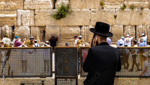Obraz na płótnie An Orthodox Jew uses a cell phone in front of the Western Wall in Jerusalem w salonie