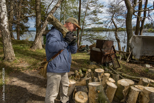 Stockholm, Sweden A man carries wood to a woodpile for later splitting as part of a community project.