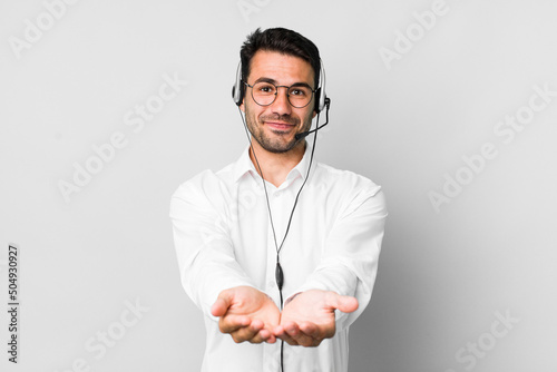 young adult hispanic man smiling happily with friendly and  offering and showing a concept. telemarketer concept