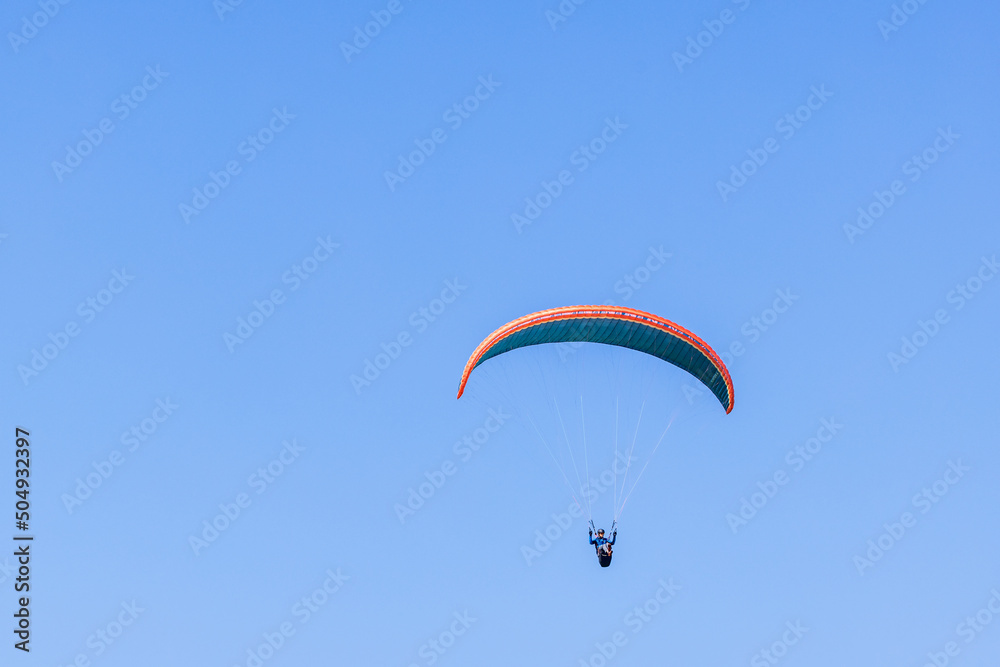 Paraglider flying high up at a blue sunny sky Paraglider flying high up at a blue sunny sky