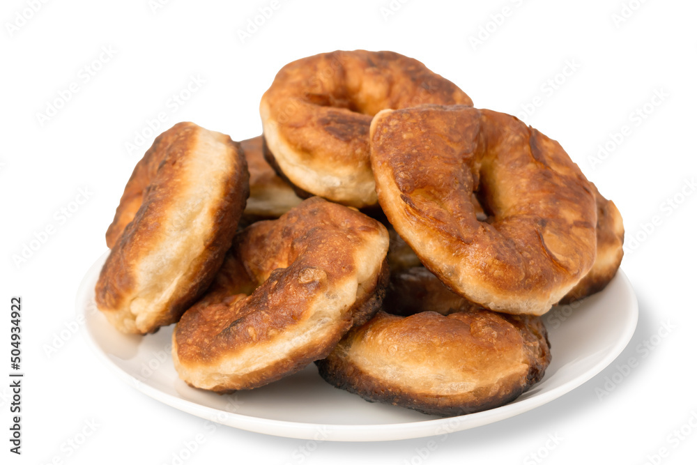 Pile of fresh homemade round donuts in a plate isolated on white background. Brown fried doughnuts. Yeast dough products, sweet pastries isolate.