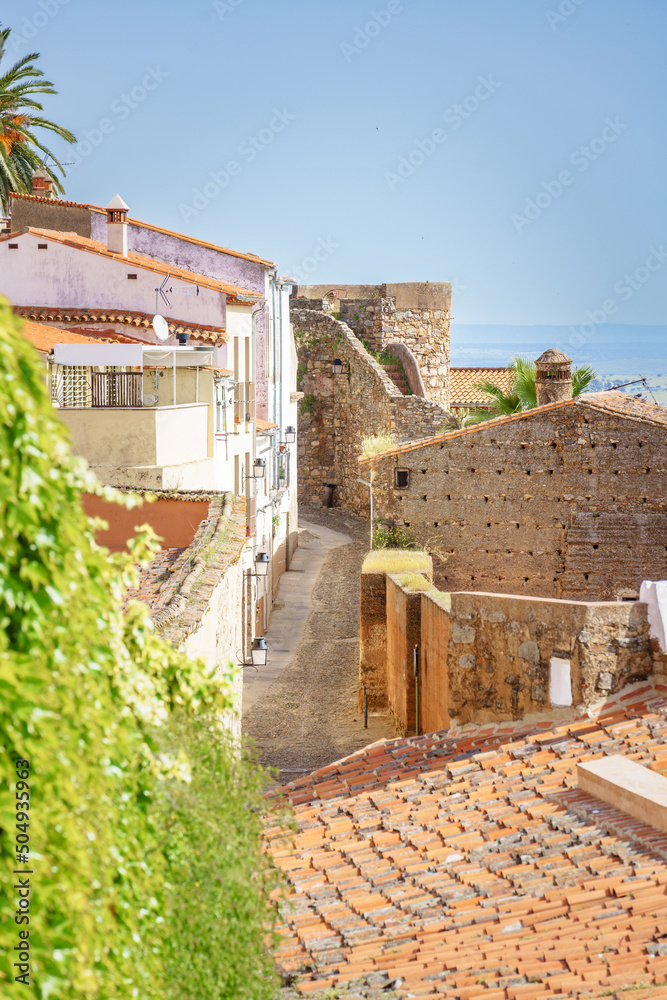 Elevated view of a picturesque narrow street known as adarve next to Almohades ramparts in Cáceres 