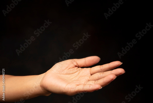Praying hand with faith in religion and belief in god on black background. Power of hope and devotion.