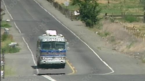 OLDER CHARTER BUS DRIVING ALONG FREEWAY