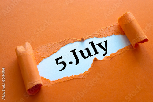Calendar date. July 5 written under torn paper. photo