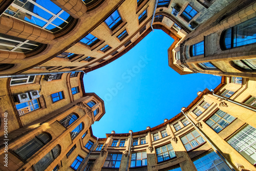 Courtyard well in old residential house from historical center of Saint Petersburg, Russia. Courtyard of well, view from below of the blue sky