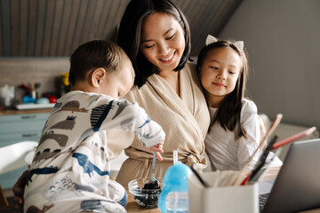 Happy asian family using laptop while spending time together