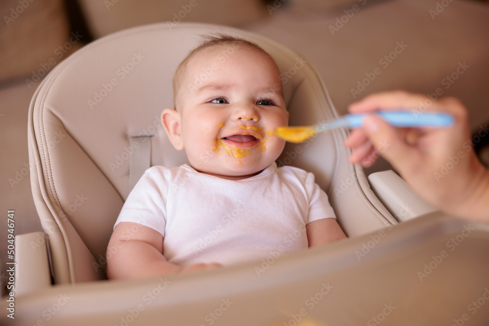 Baby eating porridge in high chair Baby eating porridge in high chair