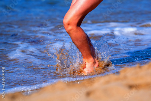 Cute young girl jumping in sea water. Summer holiday  travel  happy childhood and rest concept. Horizontal image.