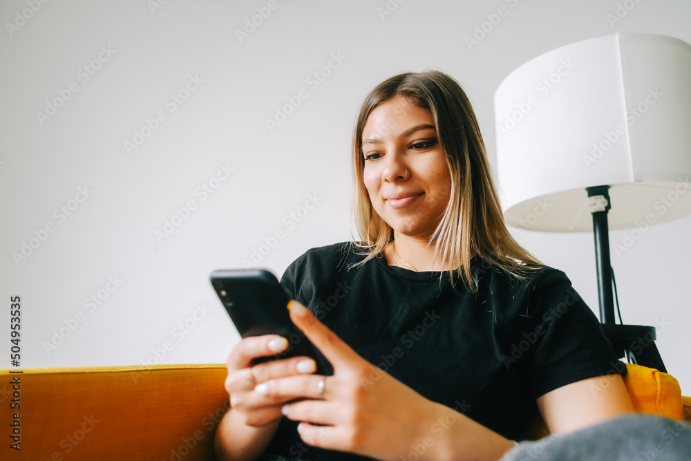 Young attractive caucasian woman using mobile phone at home. Young attractive caucasian woman using mobile phone at home.