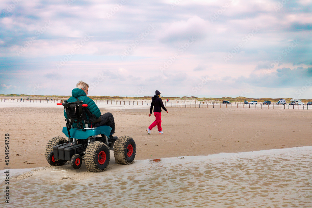Mann im Strand-Rollstuhl, Sankt-Peter-Ording, Schleswig-Hostein, Deutschland Mann im Strand-Rollstuhl, Sankt-Peter-Ording, Schleswig-Hostein, Deutschland
