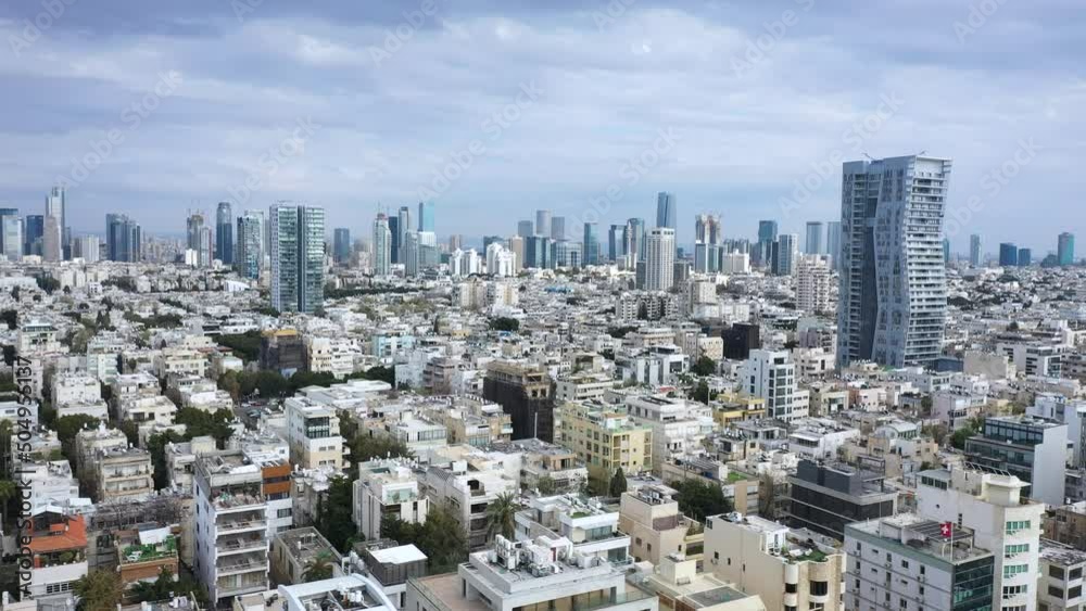 Tel Aviv, Israel skyline featuring key buildings and urban density on a sunny day with blue sky and light cloud. Elegant aerial tracking drone shot from medium height. Tel Aviv, Israel skyline featuring key buildings and urban density on a sunny day with blue sky and light cloud. Elegant aerial tracking drone shot from medium height.